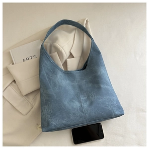 Close-up of a large light blue washed fabric tote bag with a vintage hobo design texture