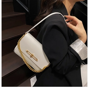 Close-up of elegant white tote bag with thick gold chain and stylish metal clasp buckle
