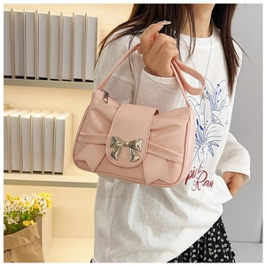 Detail of pink pleated handbag featuring bow design and silver metallic clasp on shoulder