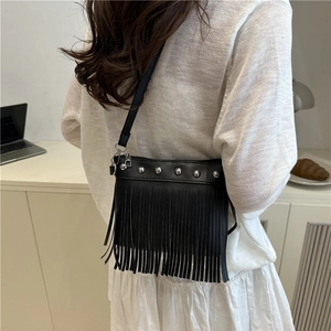 Minimalist black fringe crossbody bag with silver rivets shown on a female model