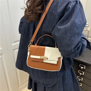 Two-tone caramel and cream PU leather crossbody bag with golden turn-lock on a model