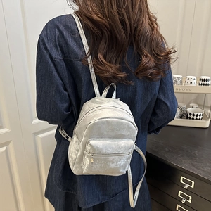 Minimalist silver metallic mini backpack for women featuring shiny textured synthetic leather