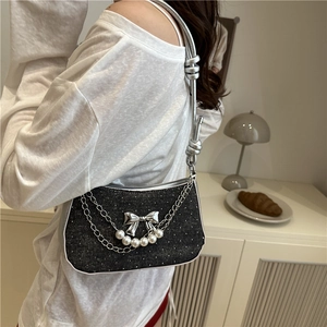 Sparkly chic shoulder bag with silver butterfly chain and pearls on fashion model
