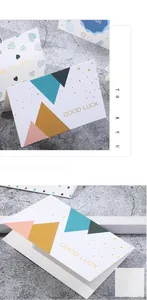 Detailed view of folded gift cards featuring gold foil lettering and geometric patterns