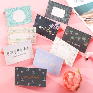 Close-up of assorted watercolor thank you cards with gold foil stamping and envelopes