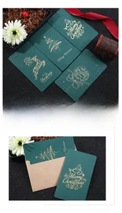 Macro view of vintage dark green Christmas cards with gold foil stamps and kraft envelopes