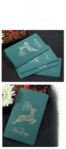 Close-up of vintage dark green card with gold foil reindeer and Christmas greetings