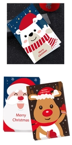 Close-up of Christmas cards with polar bear, Santa and reindeer on white cardstock