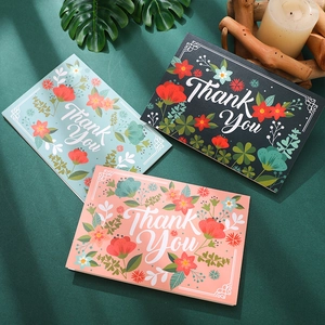 Floral Thank You cards in grey, cyan and coral pink with envelopes on a green background