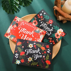 Elegant gold foil Thank You cards with floral patterns on rustic wooden tray