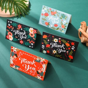 Macro detail of elegant gold-stamped Thank You cards with floral patterns and envelopes