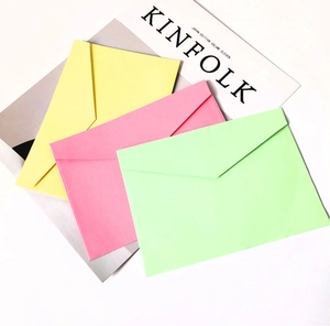 Close-up of three macaron-colored envelopes in yellow, pink, and mint green with V-flap