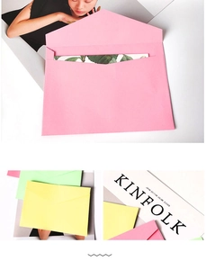 Detail of colorful matte envelopes with V-flap and floral liners on white desk