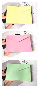 Detail of macaron yellow, pink, and green kraft paper envelopes with classic triangle flap