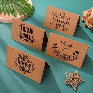 Macro detail of vintage kraft paper thank you cards with artistic black typography and envelopes