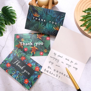 Macro view of tropical rainforest thank you cards with monstera leaves and gold pen