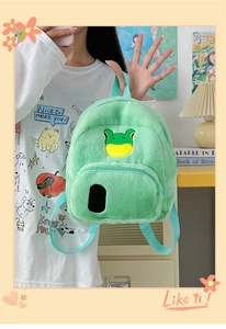 Dettaglio del mini zaino in peluche verde chiaro con simpatica toppa a rana cartoon
