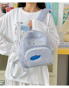 Dettaglio dello zaino di peluche con ricamo a squalo e texture in finta pelliccia
