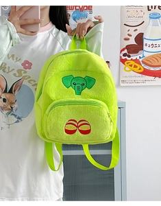 Dettaglio dello zaino in peluche verde neon con ricamo a forma di elefante e trama morbida