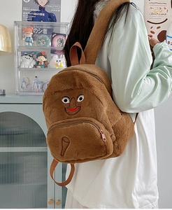 Dettaglio dello zaino in peluche marrone con ricamo a forma di cartone animato