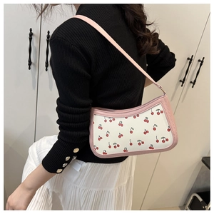 Detail of pink leather underarm bag with sweet cherry print on the shoulder strap