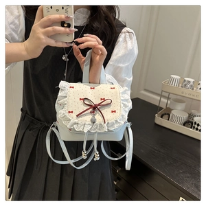 Close-up of lolita-style mini bag with red bow, lace trim, and heart patterns