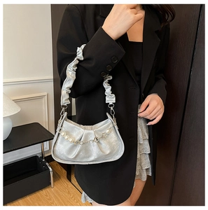 Detail of silver pleated cloud bag with pearl chain and metallic flower accents