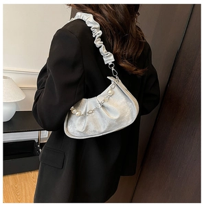 Silver crescent pleated shoulder bag with pearl chain detail shown on a model