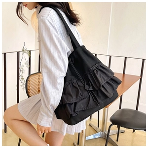 Detail of black pleated canvas tote bag featuring stylish ruffles and large capacity