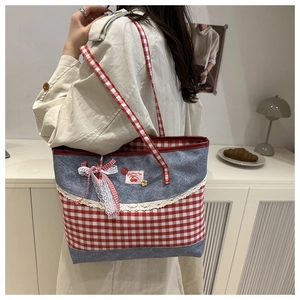 Detail of a denim tote bag with red-white plaid pattern and sweet cherry embroidery