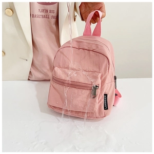 Close-up showing the waterproof nylon fabric performance on a pink mini backpack