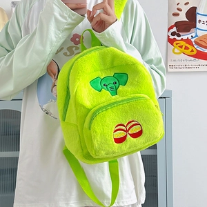 Zaino di peluche verde neon con ricamo di elefante indossato da una modella