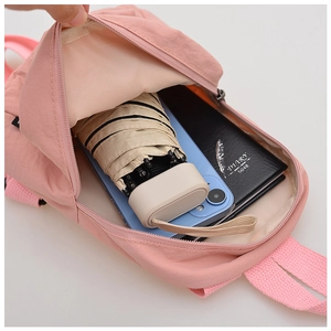 Detail of pink nylon backpack interior showing capacity for phone, umbrella and diary