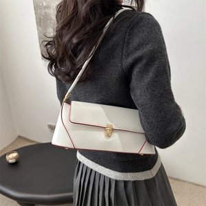 White baguette underarm bag with red contrast edges and gold clasp shown on a model