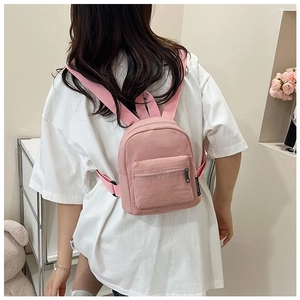 Rear view of a model wearing the pink mini nylon backpack with front zipper pocket