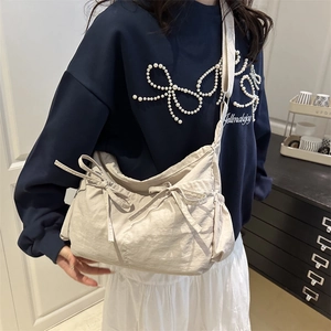 Chic pleated tote bag in cream white nylon with bow accents and drawstring side pockets