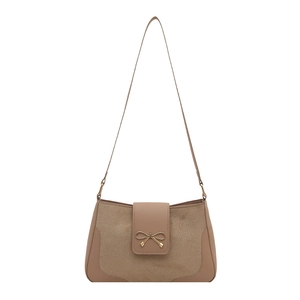 Minimalist earth-tone crossbody bag with suede texture and golden bow buckle detail