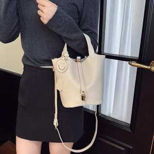 Elegante borsa a secchiello in pelle bianco crema con manici e lucchetto dorato