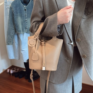 Elegante borsa a secchiello beige in pelle martellata con tracolla e manico