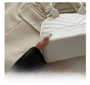 Detail showing white chevron quilted leather shell bag with gold buckle hardware