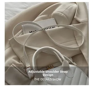 Detail showing the adjustable shoulder strap and V-shaped quilted texture of white shell bag