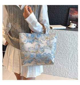 Detail of vintage floral jacquard tote bag with classic dark bamboo top handle