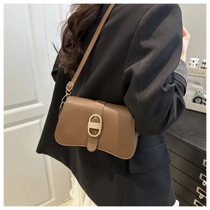 Detail view of a vintage brown leather shoulder bag with a gold D-ring metal buckle