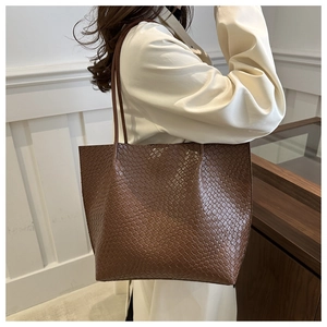 Detail of the woven texture and premium dark brown leather on this large tote bag