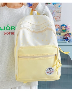 Detail of star pattern canvas backpack with front zipper pocket and embroidered logo patch