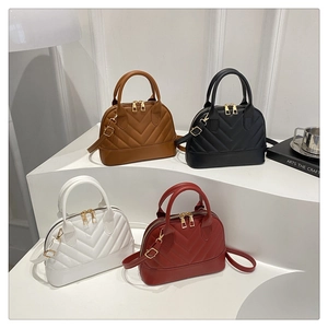 Detailed close-up of shell-shaped handbags in four colors with V-quilted stitching and gold hardware