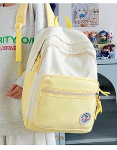 Side view of large capacity school backpack in yellow and white star print canvas