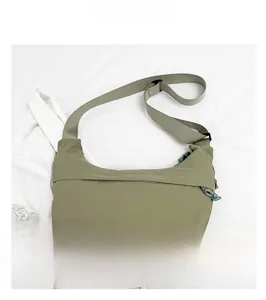 Detail showing olive green crescent crossbody bag with durable nylon texture and strap