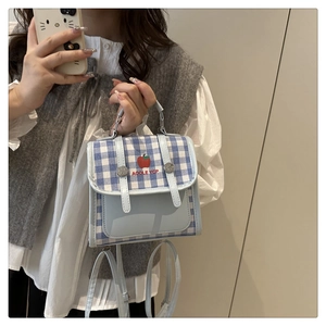 Detail of blue plaid mini backpack with apple embroidery and silver metal rings
