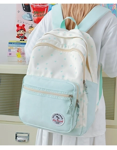 Detail of blue and white star pattern backpack showing multi-zipper layers and side pocket